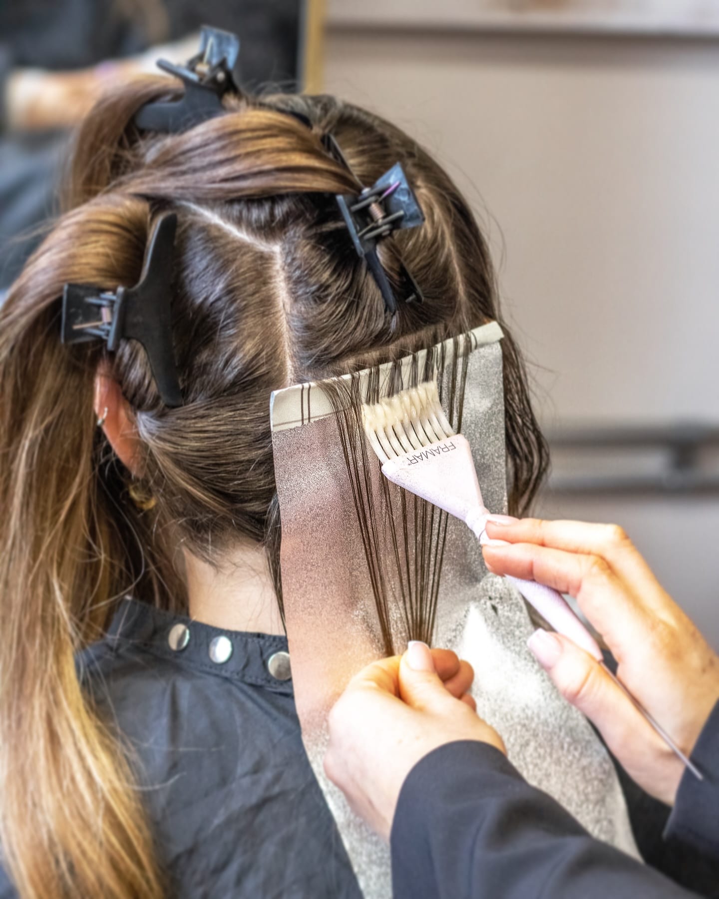 Lisa brengt zorgvuldig haarkleur aan tijdens een behandeling